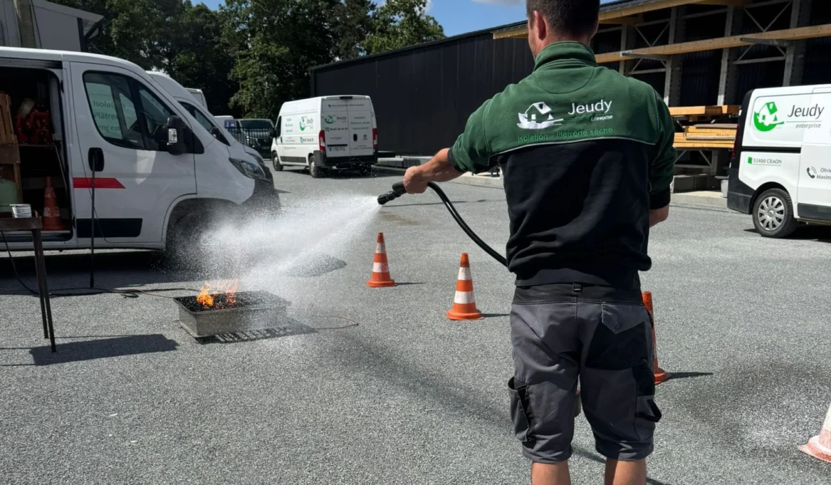 Un membre de l'équipe de l'entreprise Jeudy s'entraîne avec un extincteur
