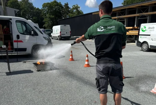 Un membre de l'équipe de l'entreprise Jeudy s'entraîne avec un extincteur